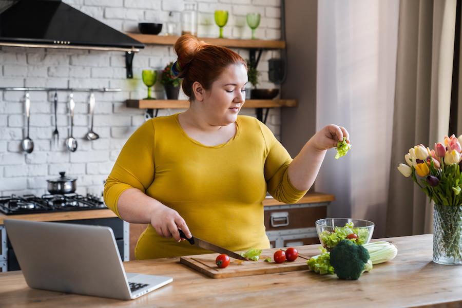 overweight woman cooking healthy food at home