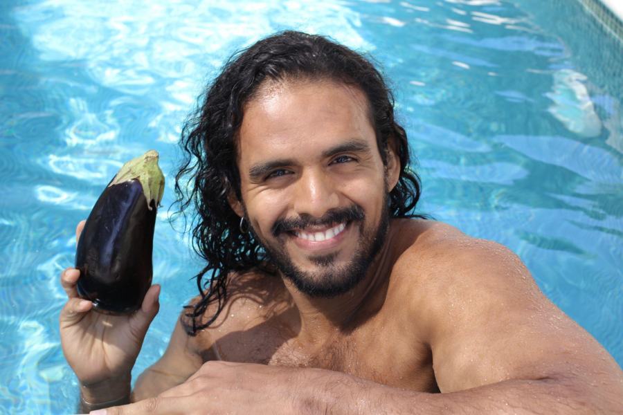 man in a swimming pool holding an eggplant