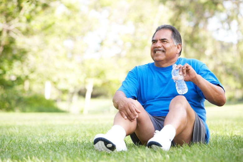 middle-aged man resting after workout on a park