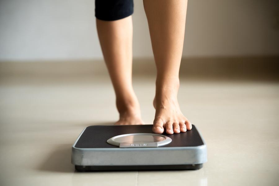 woman stepping on a scale