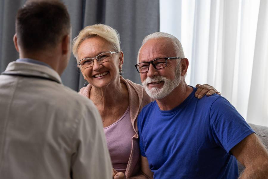 doctor explaining erectile tissue damage to happy elderly couple