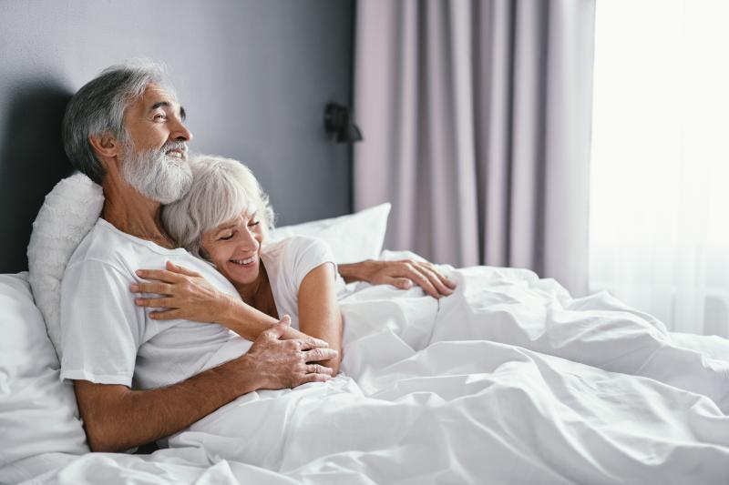 senior couple hugging and smiling in bed