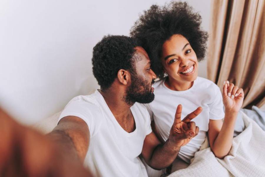 happy young black couple in bed