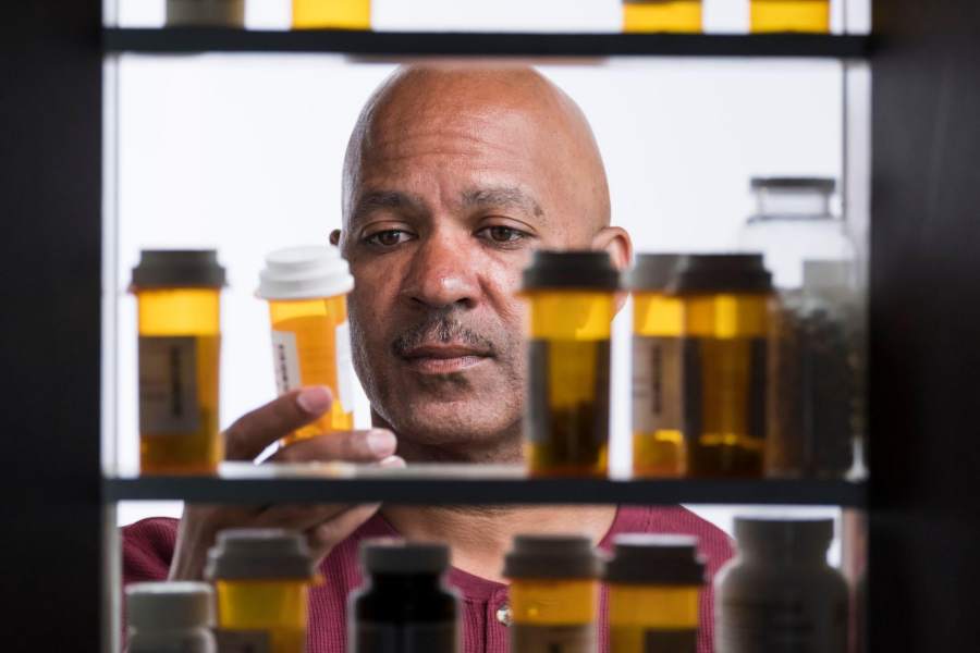 man reading the label of a prescription medicine bottle