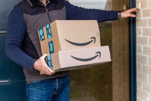 delivery man holding two amazon boxes
