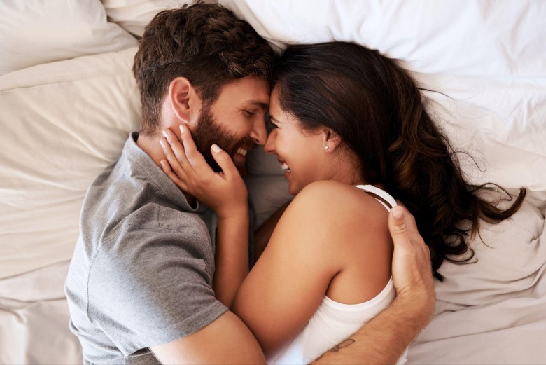 happy young couple embracing in bed