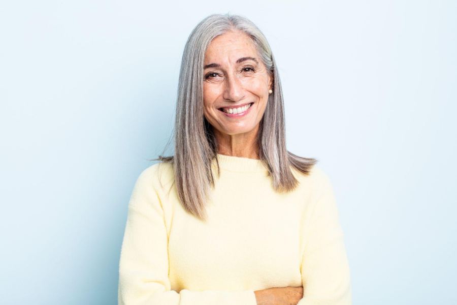 middle-aged woman with white hair smiling