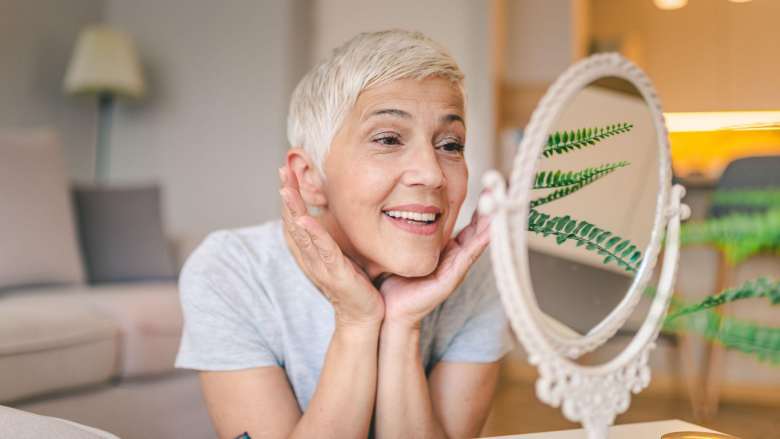 middled aged woman looking at herself in a mirror