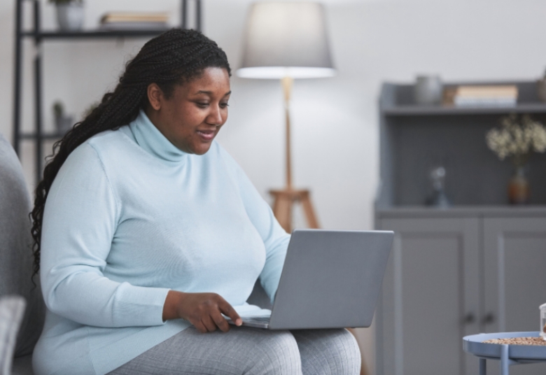 Woman Completing Online Weight Loss Evaluation at Home on Laptop